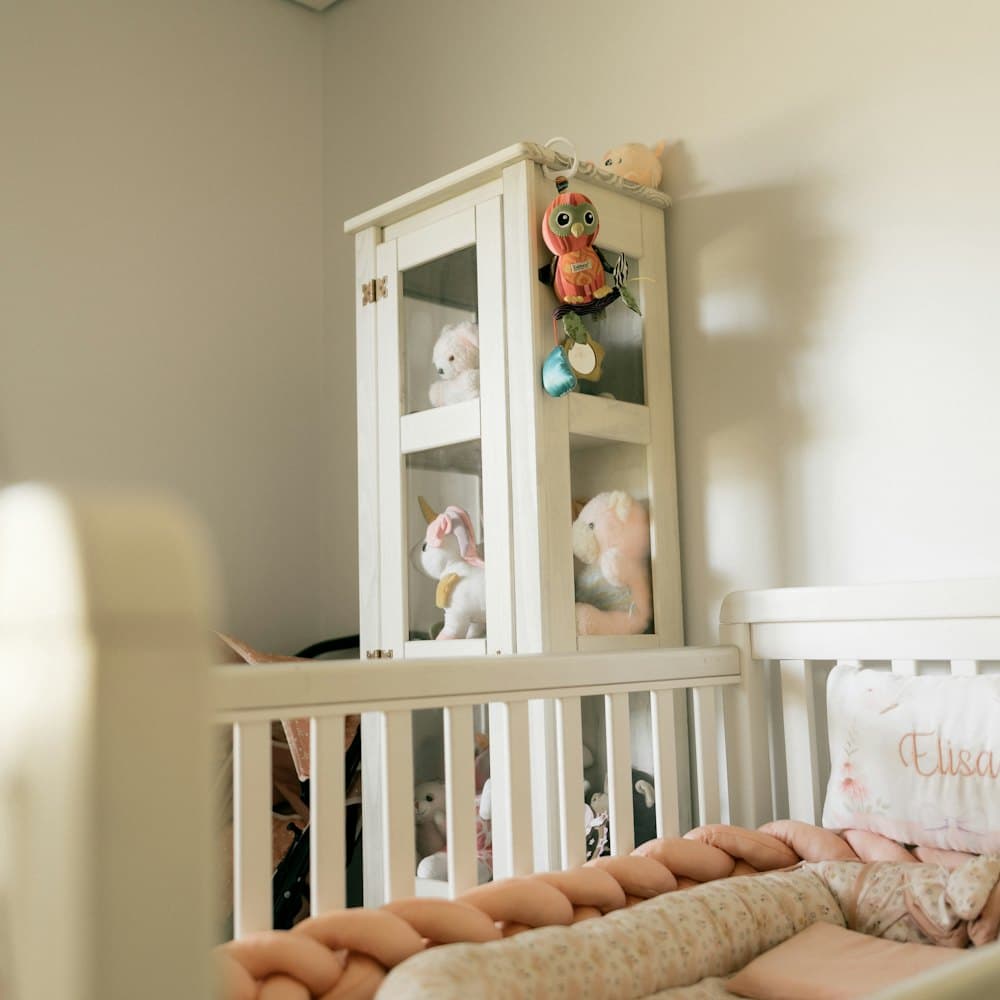 A nursery with a white cot and a chair